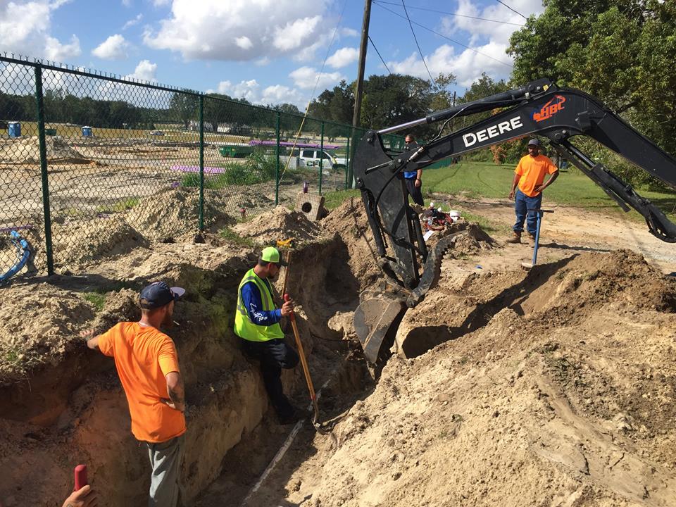 Equipment and personnel dig a hole for piping for Hull Island construction project