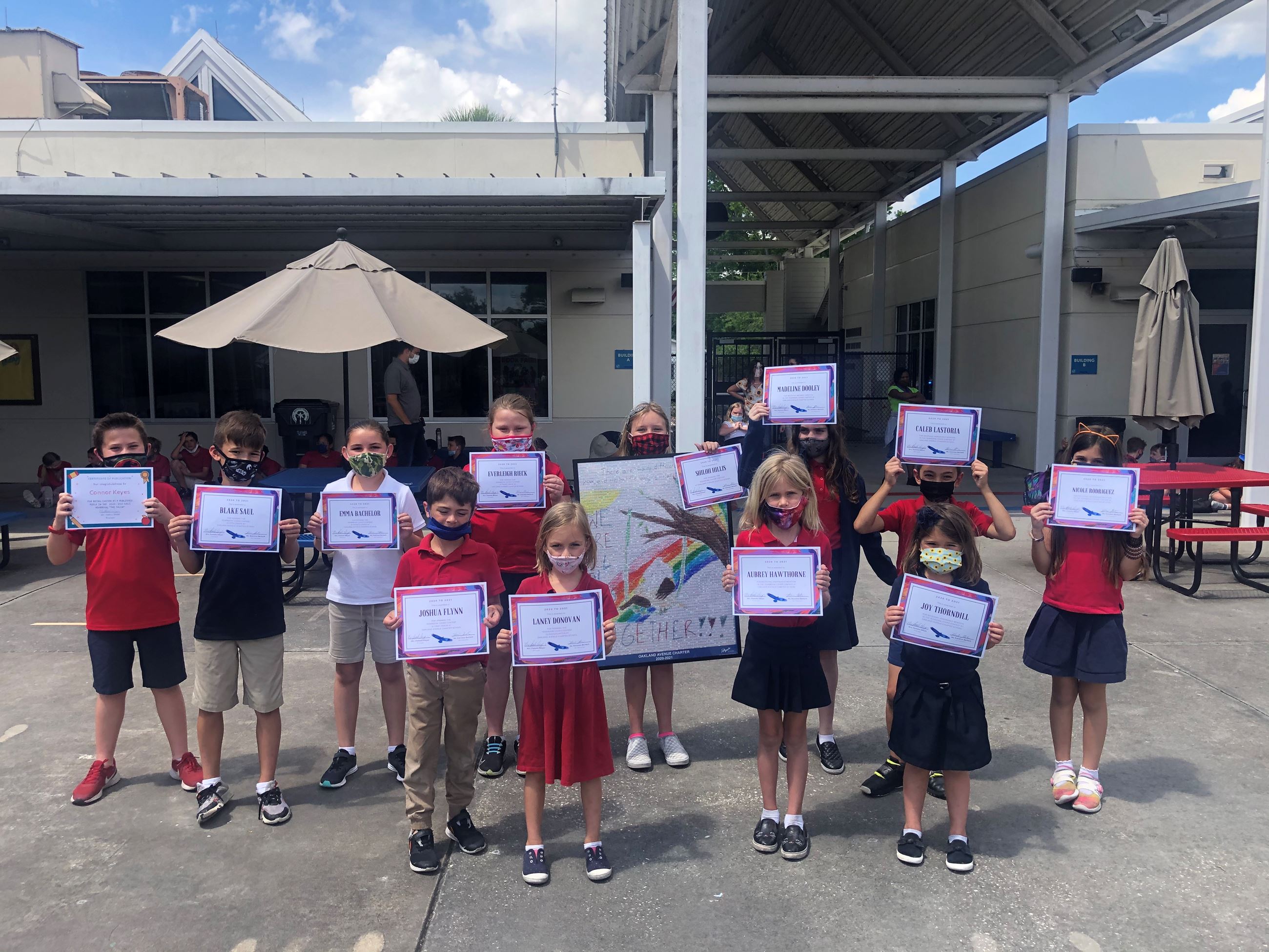 Group of students holding up certificates. 