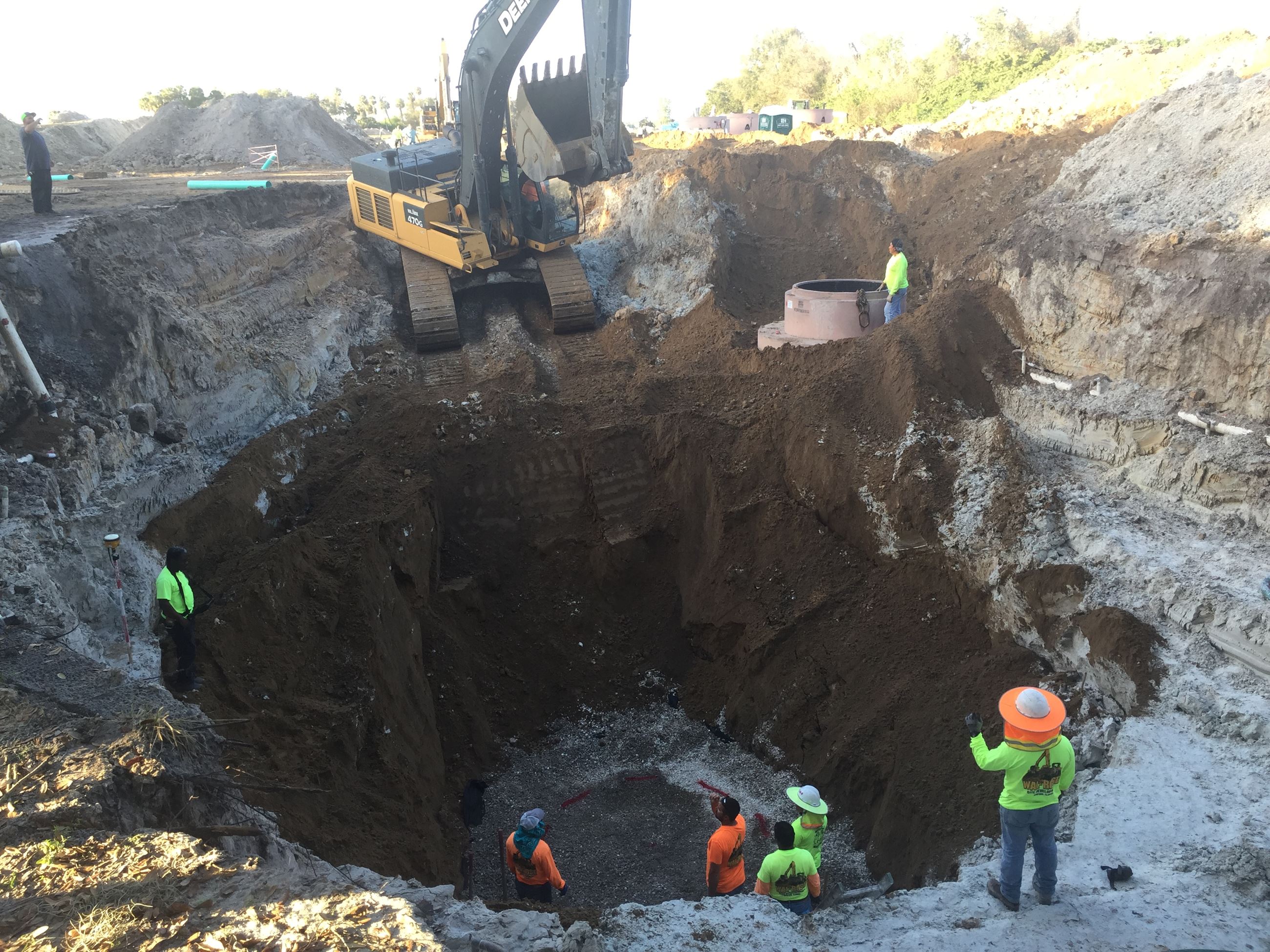 People digging hole for sanitary sewer infrastructure installation.