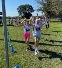 Two students "raising the roof" for one of the final laps of the Fun Run. 
